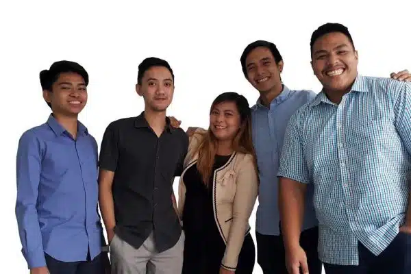 Five colleagues standing together and smiling at the camera