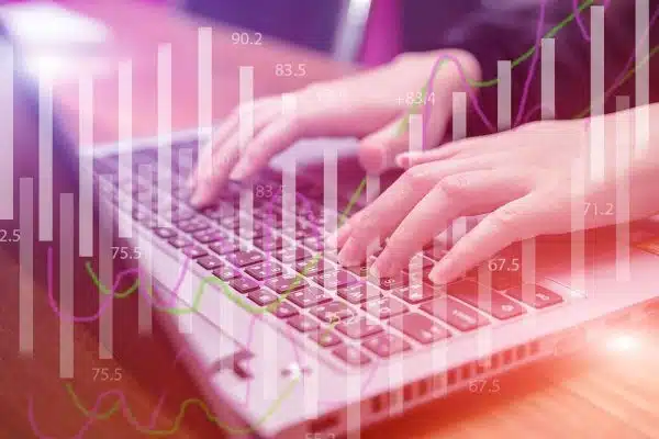 A woman typing on her laptop, with number icons visible on the screen.