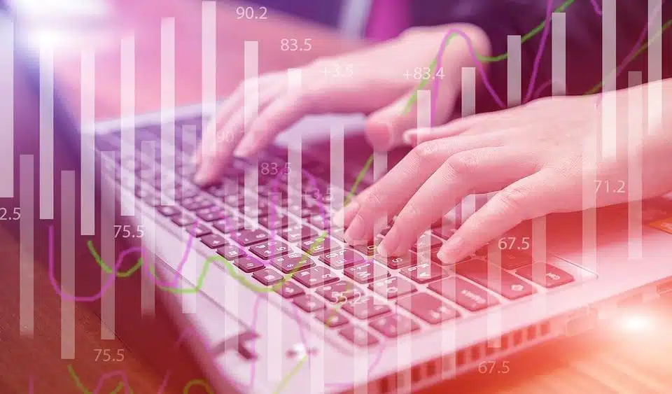 A woman typing on her laptop, with number icons visible on the screen.