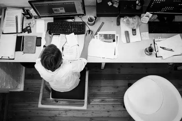 A black and white image with a woman working at her office table