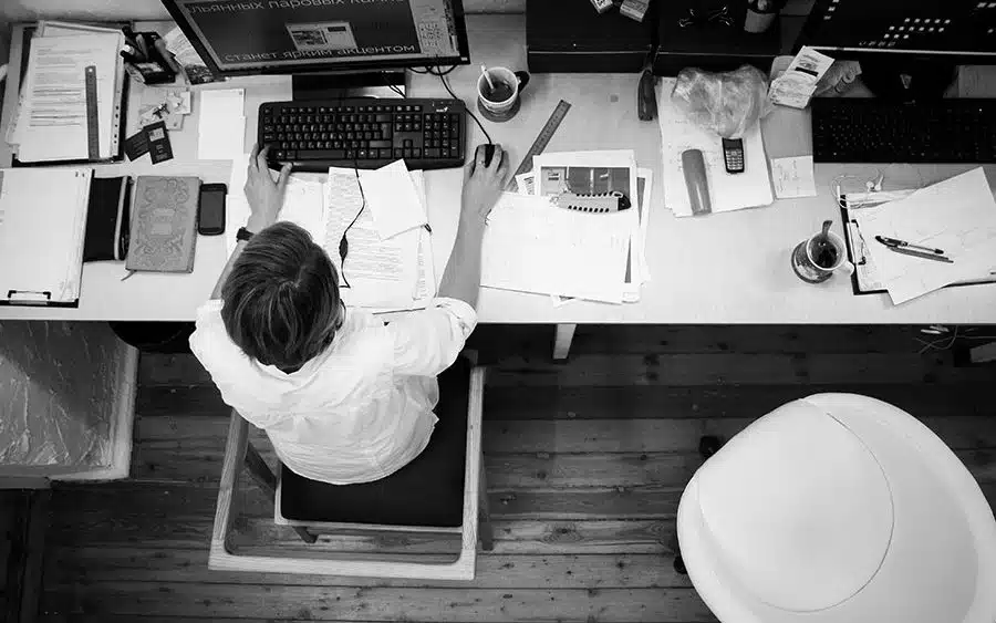 A black and white image with a woman working at her office table