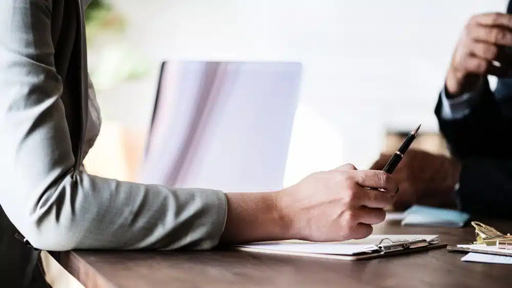 woman holding a pen while discussing