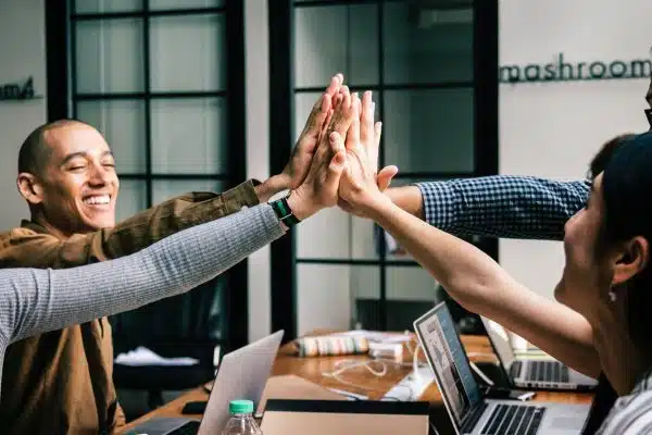 Group of colleagues joyfully celebrating with high-fives