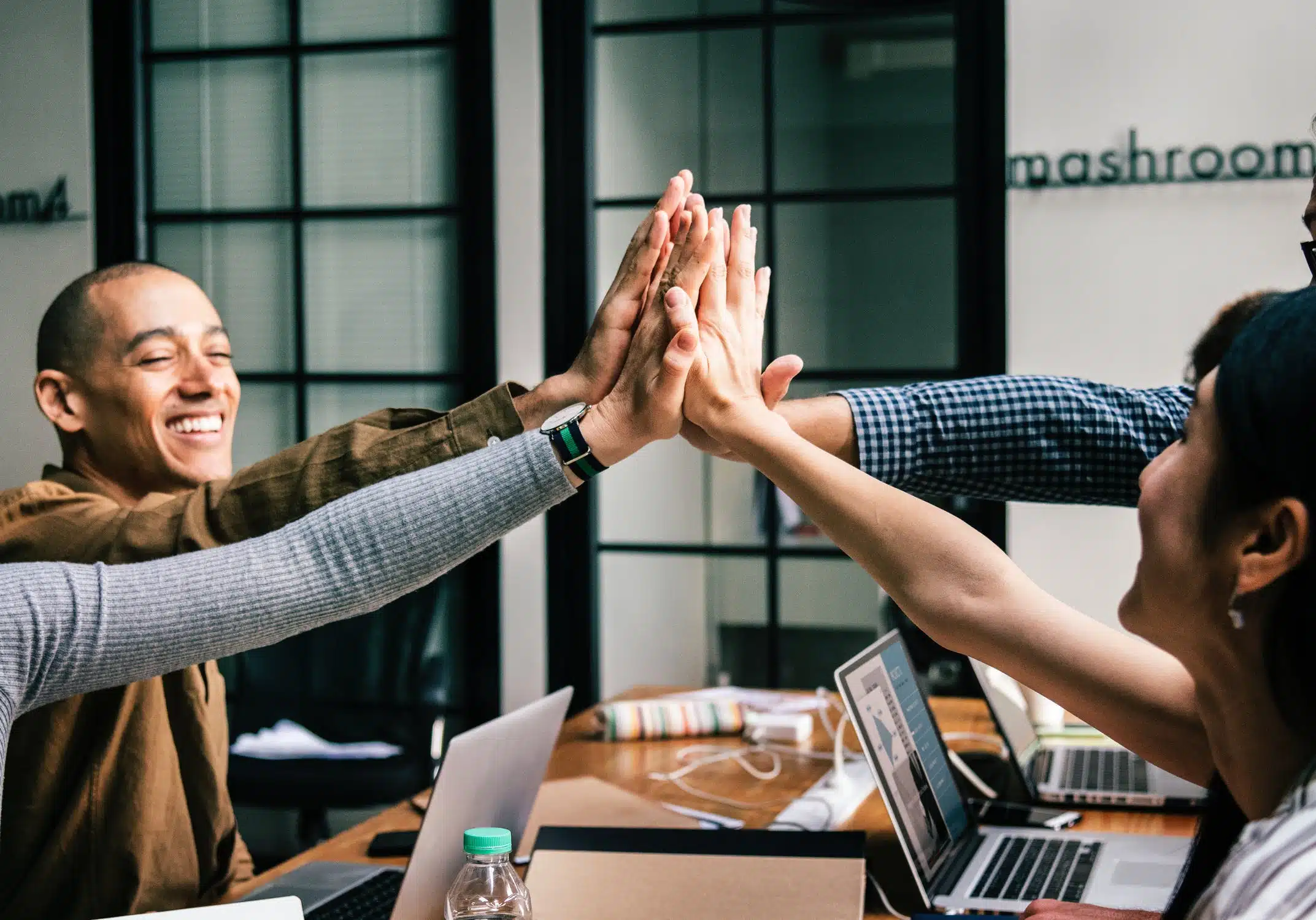 Group of colleagues joyfully celebrating with high-fives