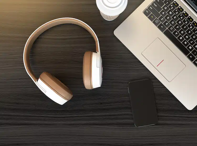 Wireless headphone, laptop PC on dark wooden table